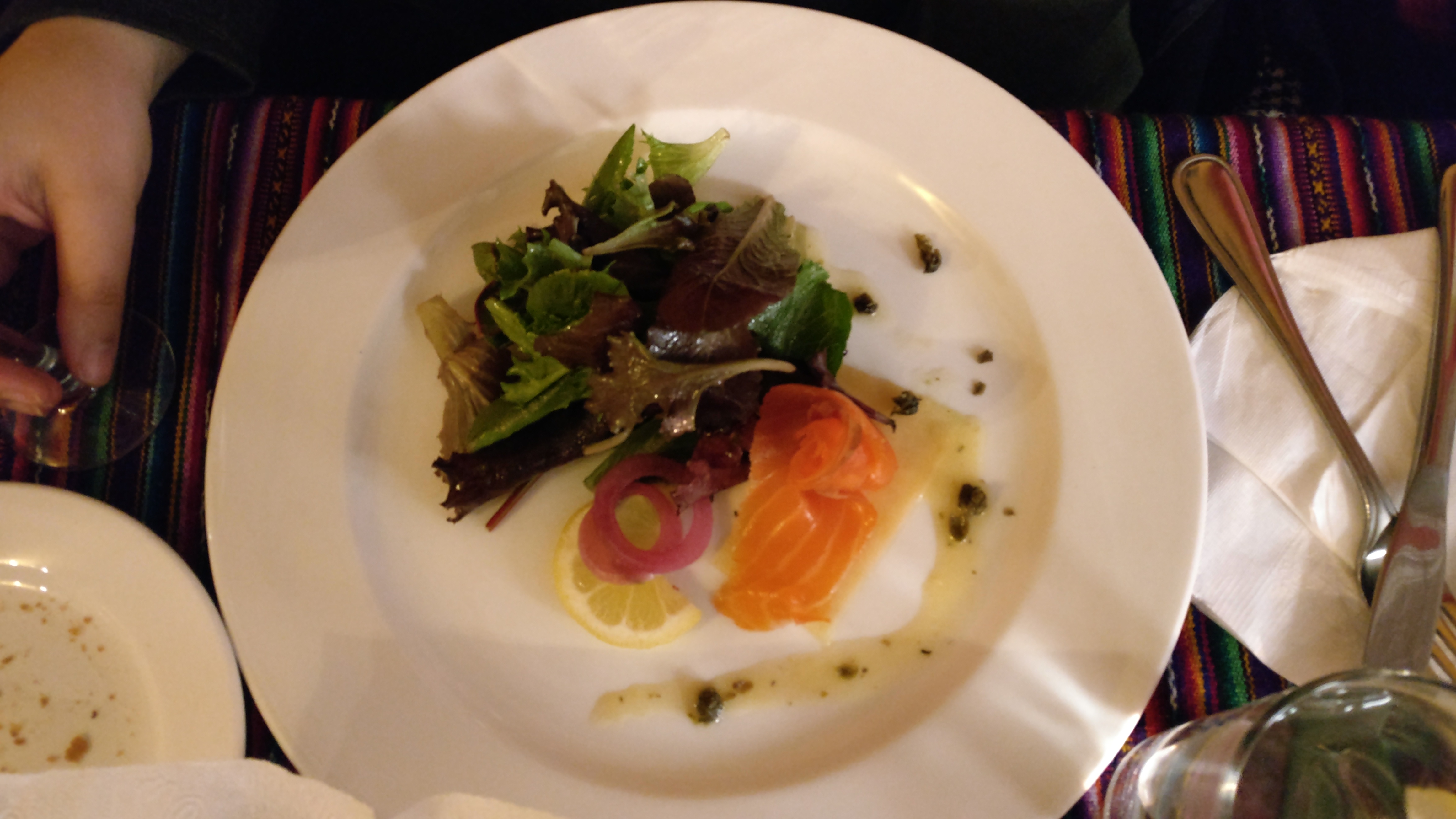 Smoked salmon slices next to a leafy green salad