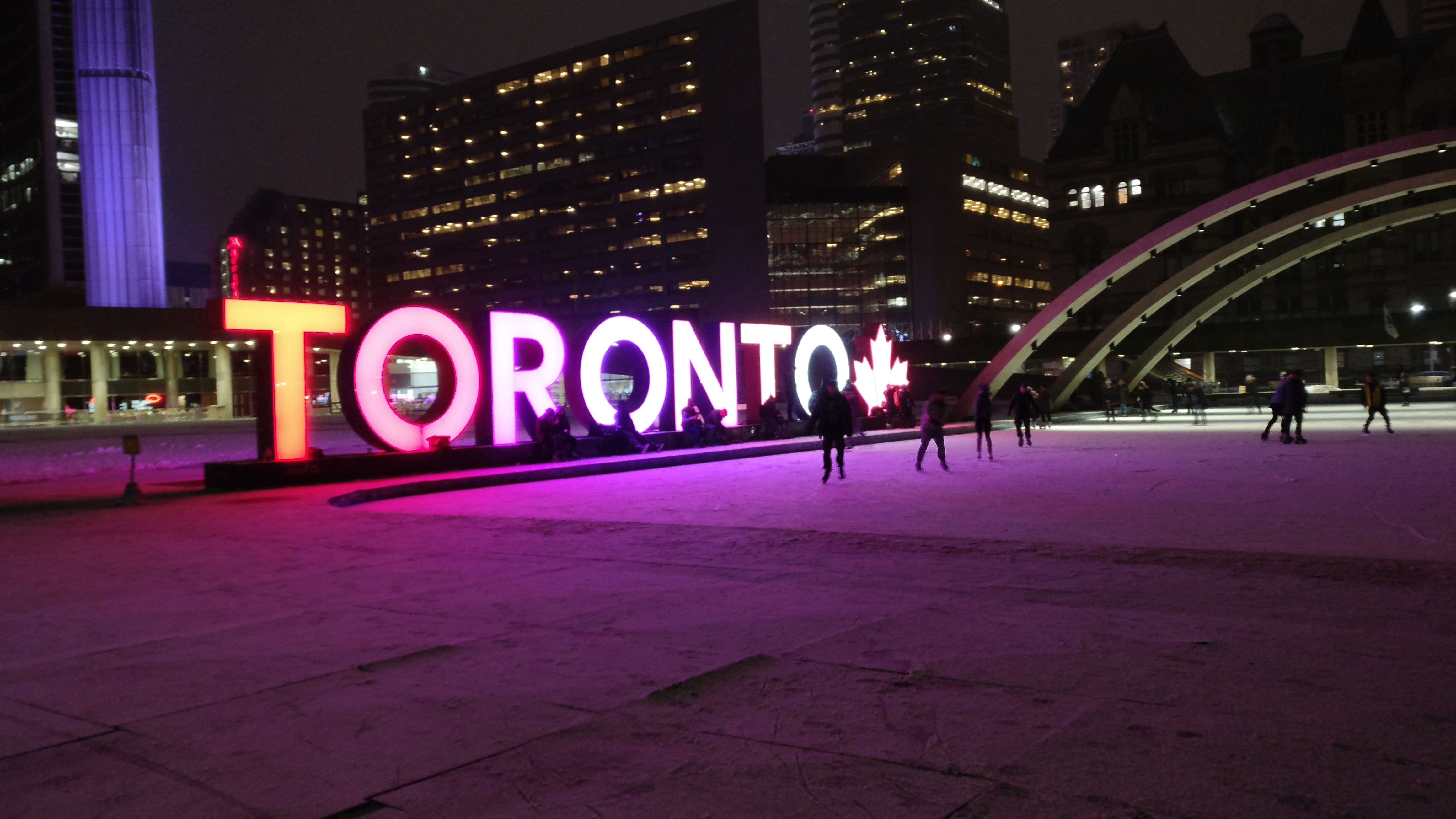 Nathan Phillip's Square outdoor ice rink with Toronto in bright coloured lights on the side